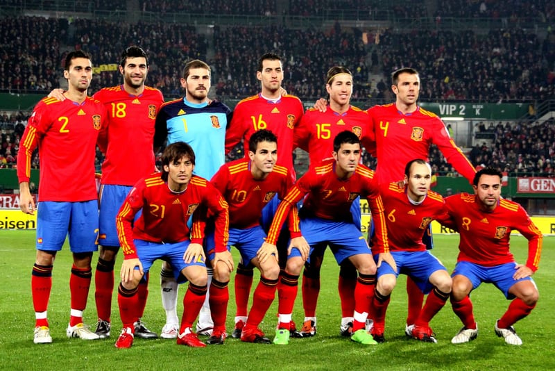 Spain national football team, a host nation and defending champions named in the story.